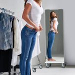Shot of an attractive young woman trying on jeans in a mirror